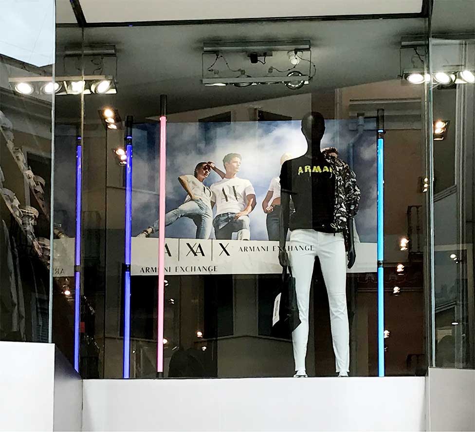 Instalación en escaparates cartelería Armani AX en puntos de venta multimarca